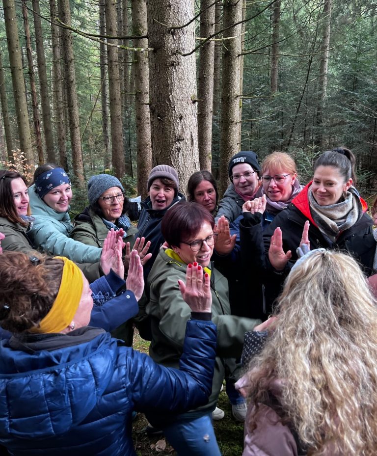 Miteinander ins Gespräch kommen Teilnehmende tauschen sich in einer gemeinsamen Runde im Wald aus.